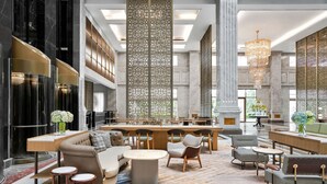 A spacious lobby with a central seating area, a bar, and a decorative partition.