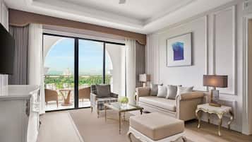 A spacious living room with a large sliding glass door leading to a balcony, a sofa set, a coffee table, and a side table with a lamp.