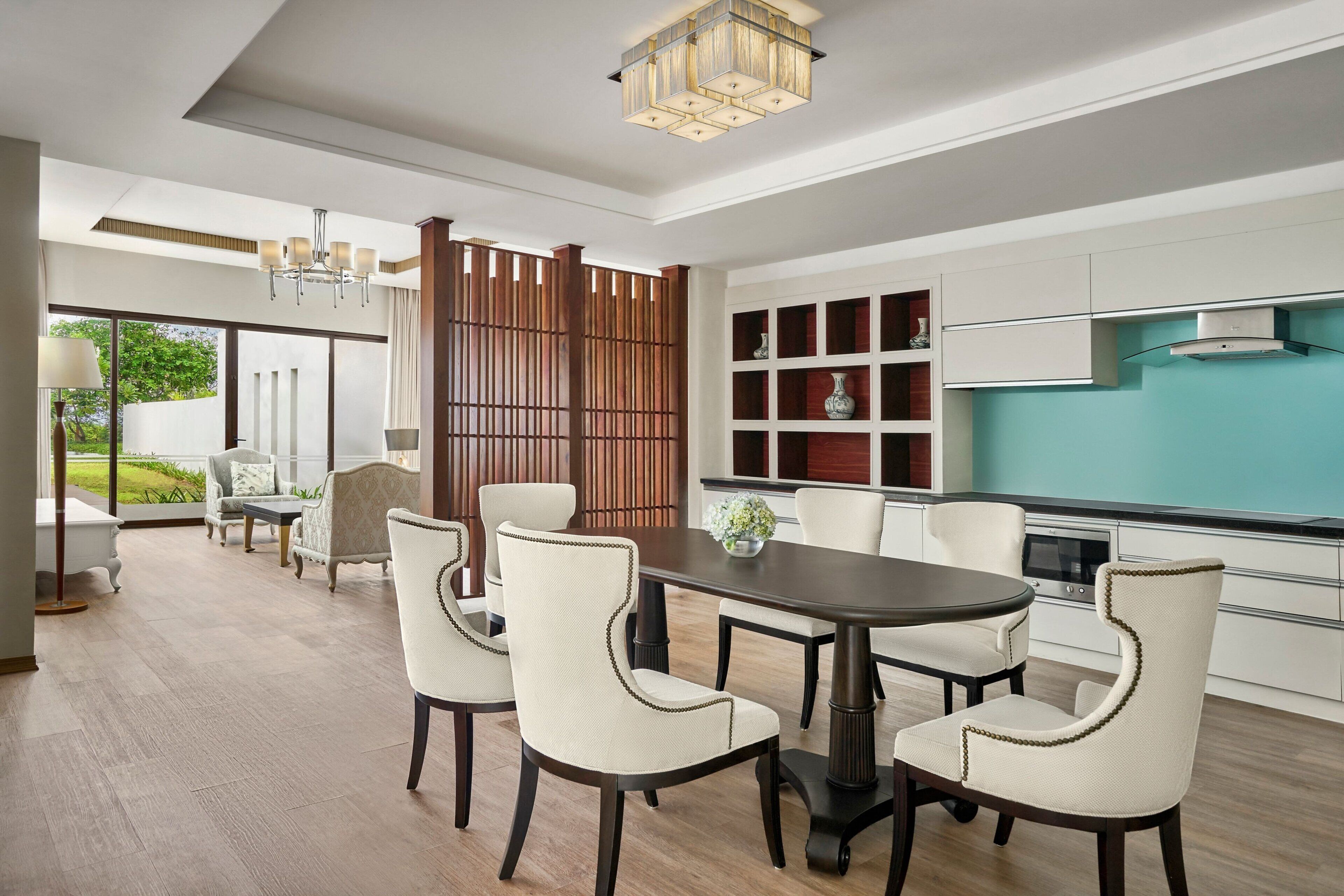 Un comedor moderno con una mesa redonda, cuatro sillas y un jarrón decorativo.