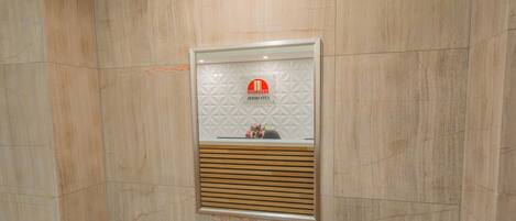 A framed mirror with a logo and a wooden bench below it.