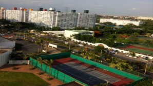 A residential area with high-rise buildings, a tennis court, and a parking lot. - Don Mueang-Challenger Impact Muangthong Thani (Pak Kret)