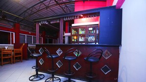 A bar area with four stools and a counter displaying bottles. - Hasara Guest House (Galle)