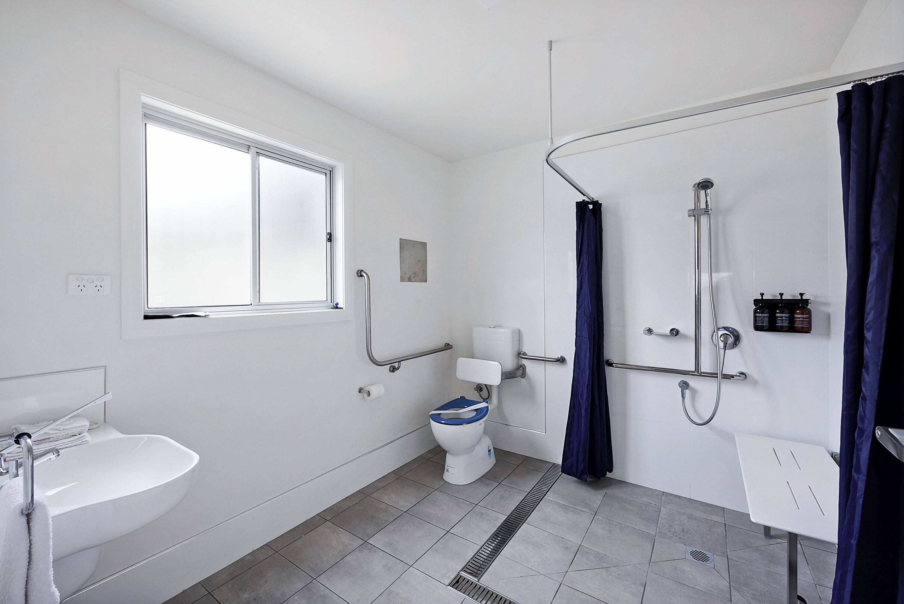 A modern bathroom with a toilet, sink, and shower.