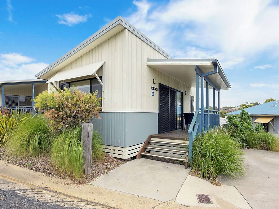A single-story building with a covered porch and a small set of steps leading to the entrance.