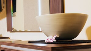 Un tazón de cerámica grande sobre una encimera de madera con un posavasos negro debajo.
