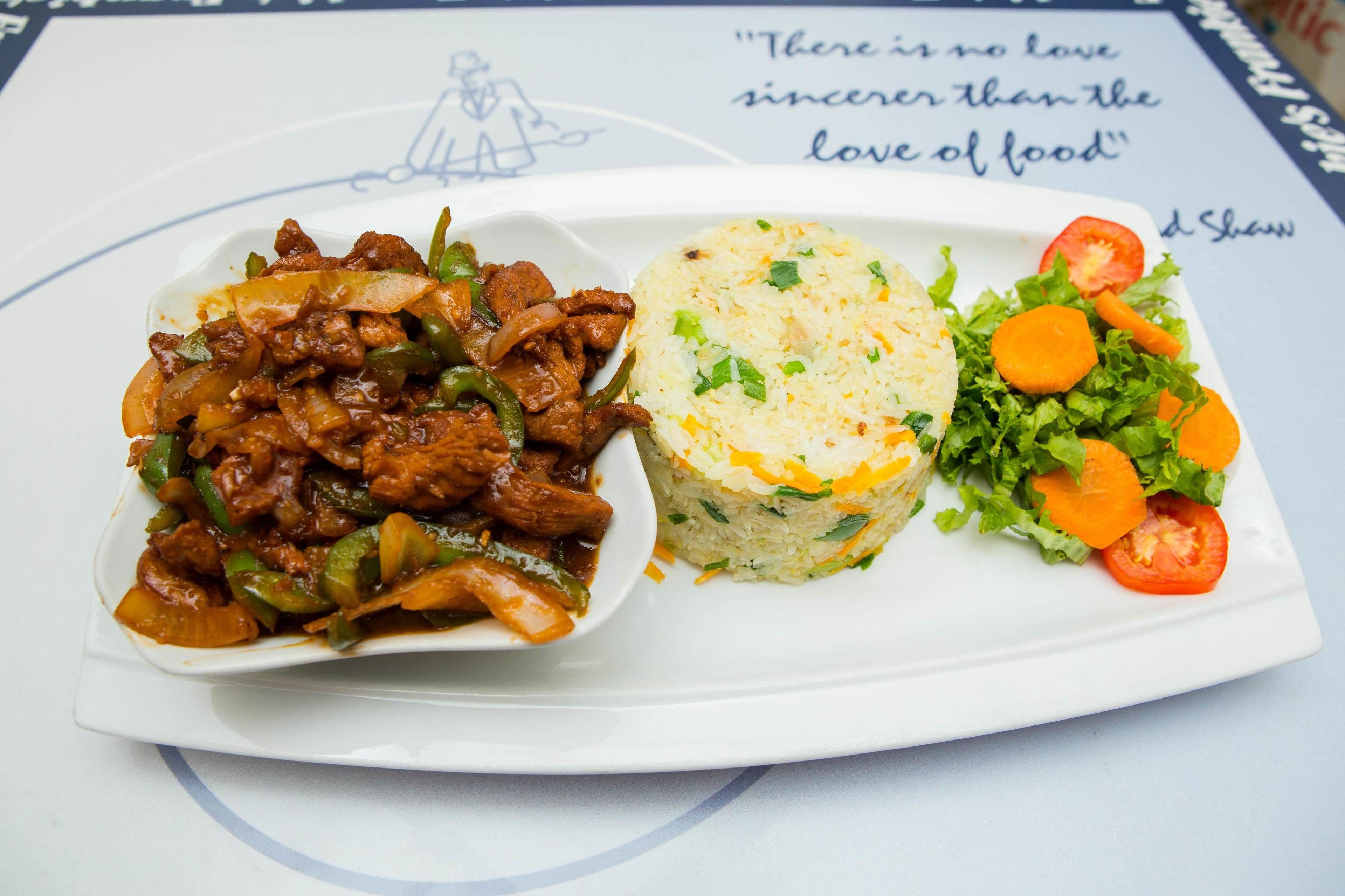A plate with beef stir-fry, rice, and a side salad.