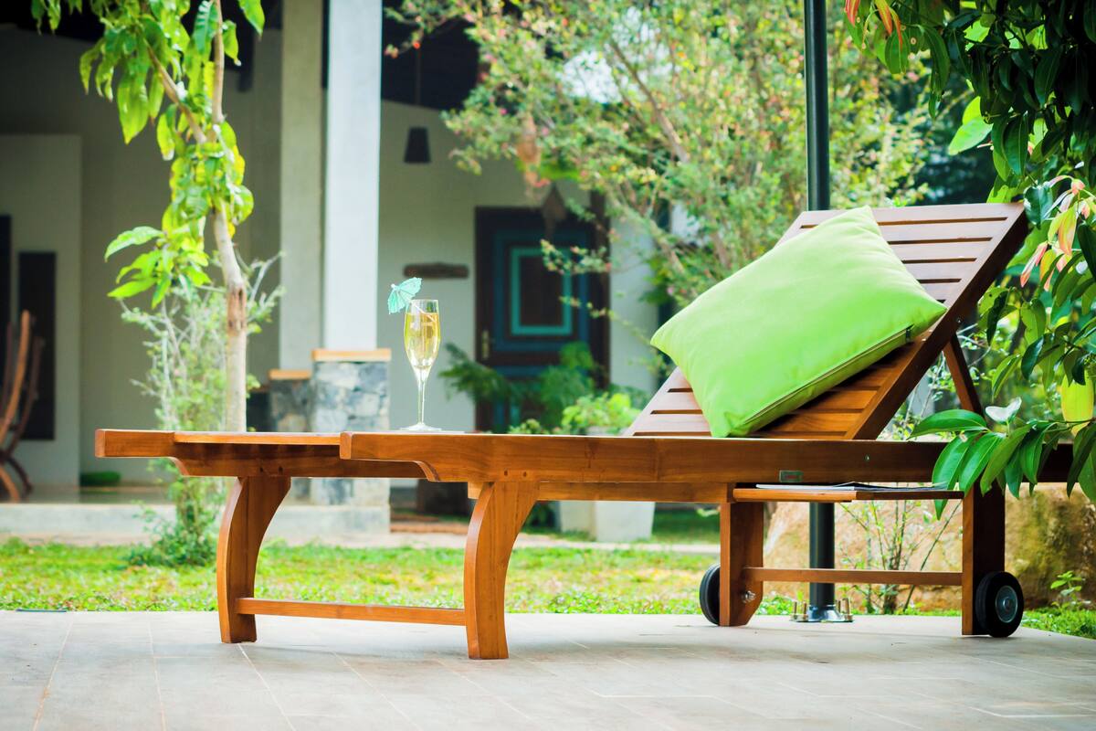 Un fauteuil de jardin en bois avec un coussin vert.