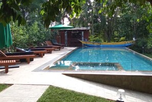 Una piscina al aire libre, camas de piscina gratis, sombrillas