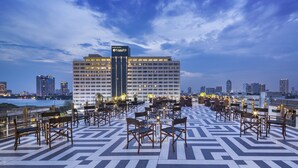 A rooftop terrace with outdoor seating and a view of a city skyline at dusk. - Hotel Once Bangkok (Bangkok)