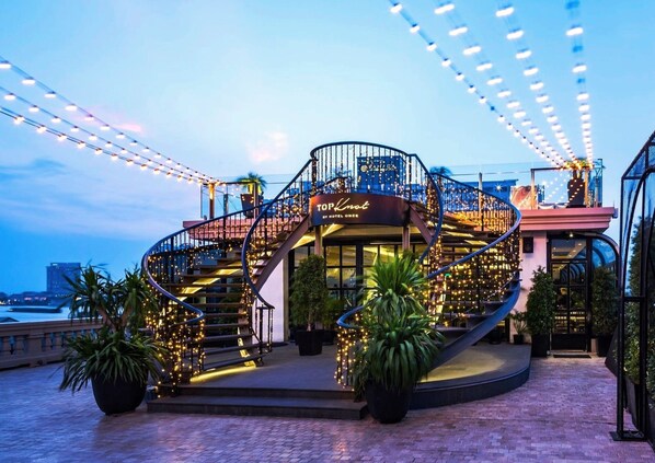 A hotel with a spiral staircase, outdoor seating area, and string lights. - Hotel Once Bangkok (Bangkok)