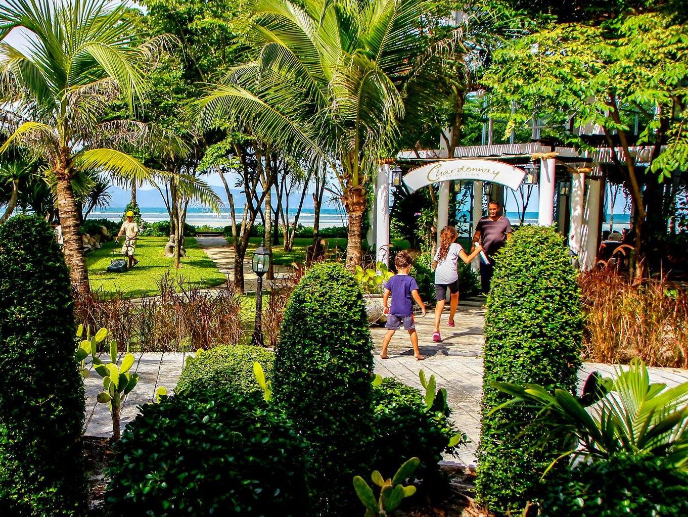 A garden pathway leading to a gazebo with a sign reading "Chandelier".