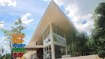 A modern building with a triangular roof and large windows. There are signs indicating amenities such as a spa and a restaurant.