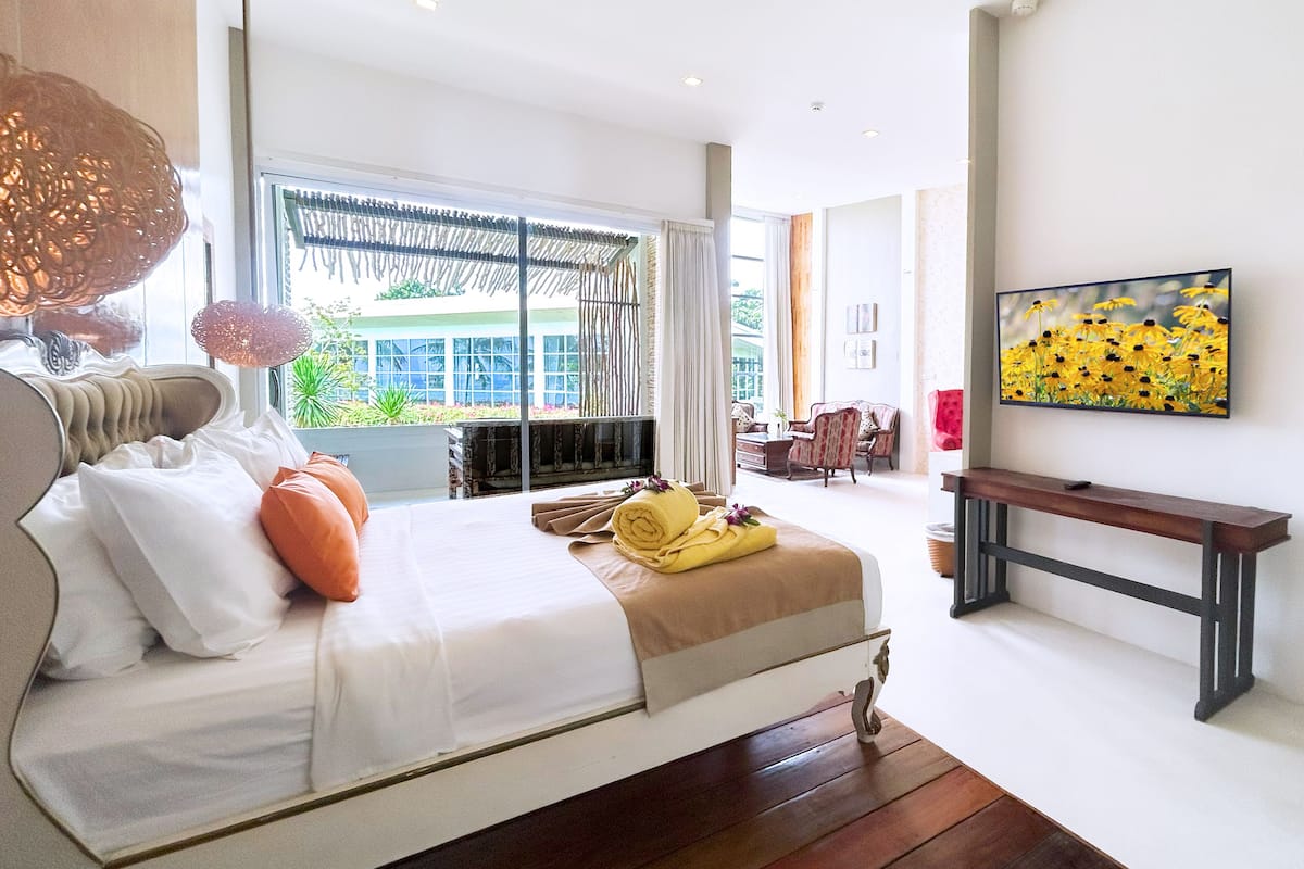 Une chambre d’hôtel moderne dotée d’un grand lit, d’une télévision et offrant une vue sur l’extérieur.