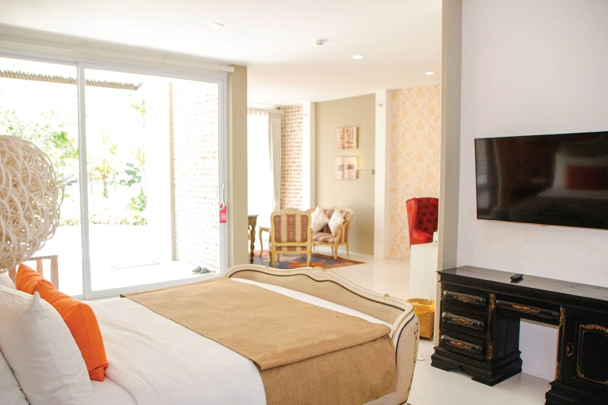 Une chambre d’hôtel avec un lit, une télévision, un bureau et une chaise.