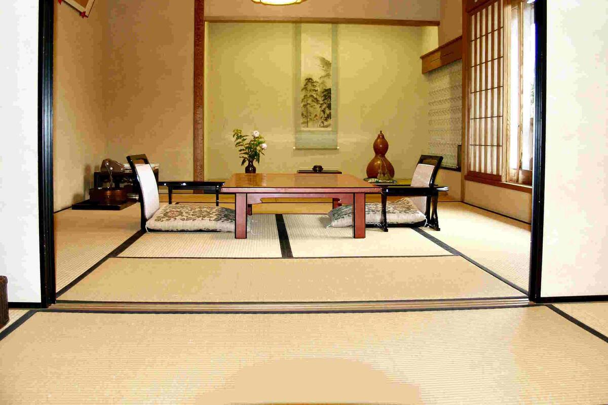 A traditional Japanese room with tatami flooring, a low table, and a shoji screen.