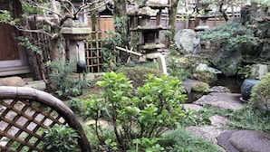 A traditional Japanese garden with stone lanterns, a small pond, and bamboo fences. - Ise Todaya Ryoan (Ise)