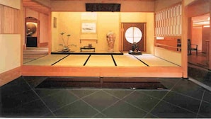 A traditional Japanese interior with tatami flooring, a shoji screen door, and a low wooden ceiling. - Ise Todaya Ryoan (Ise)