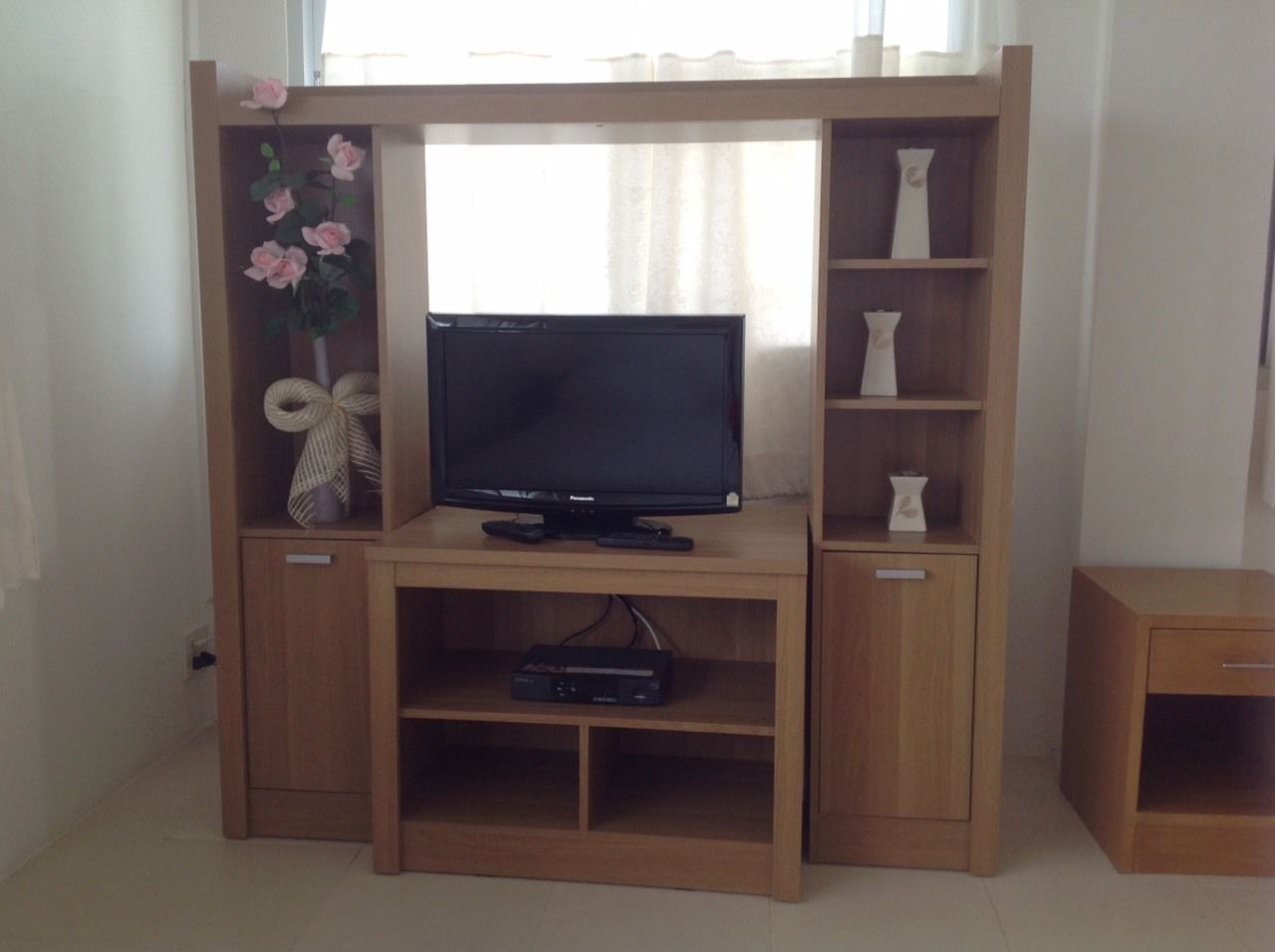 Ein Holz-Entertainment-Center mit Flachbildfernseher, Regalen und einem kleinen Schrank.