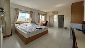 A spacious bedroom with a large bed, a dining area, and a kitchenette. - U.D.Home Apartment (Ban Chang)