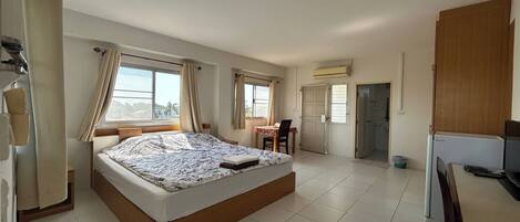 Un dormitorio amplio con una cama grande, un comedor y una kitchenette.