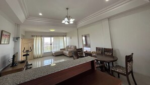 A spacious living area with a dining table, chairs, a sofa, and a TV. - U.D.Home Apartment (Ban Chang)