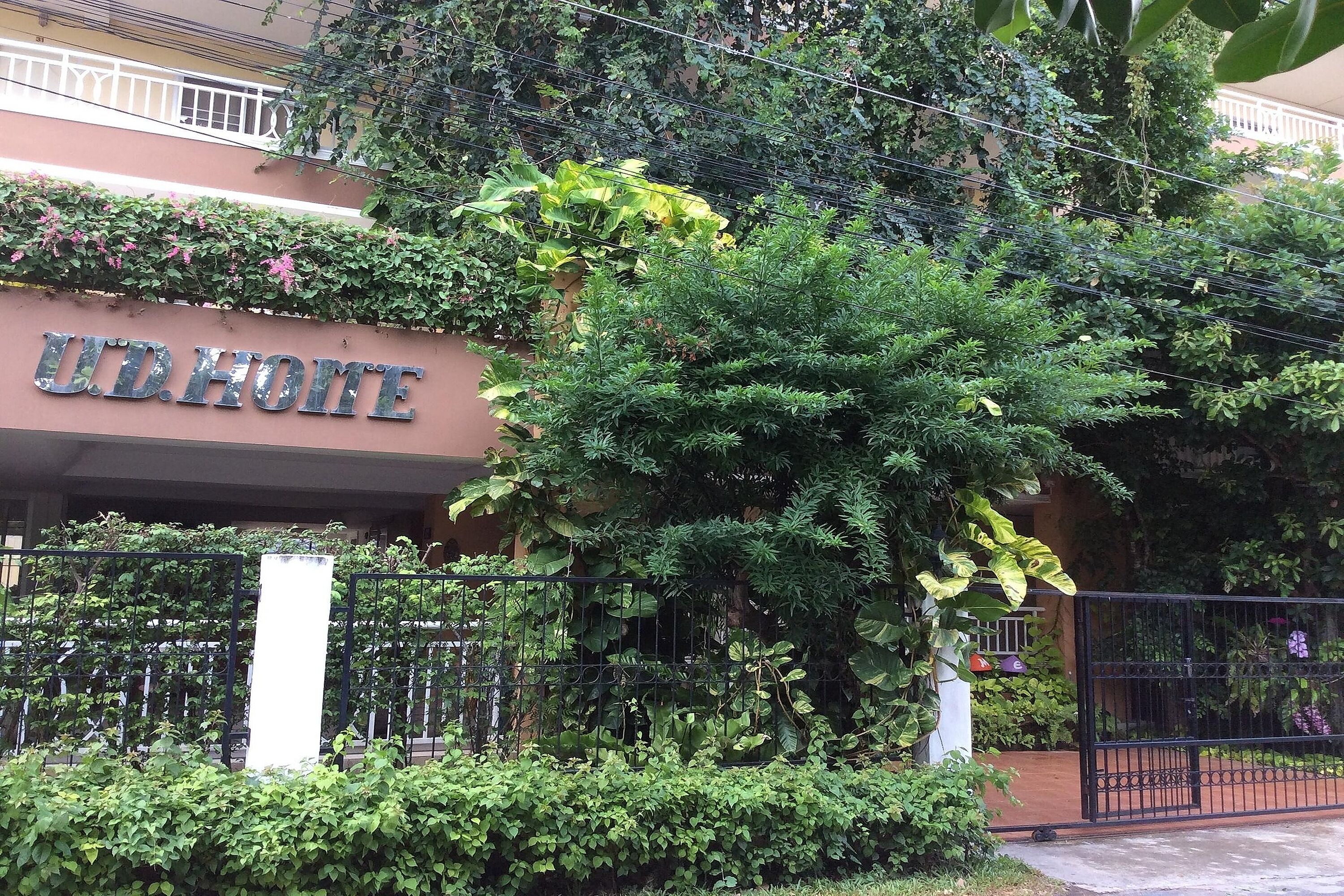 A hotel entrance with a sign reading "U.D. HOME" and a metal gate.