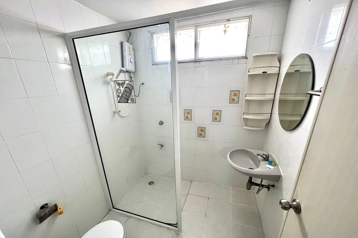 Un baño con ducha de vidrio, inodoro, lavabo y espejo.