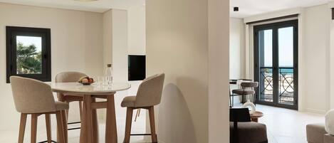 Un espace repas moderne avec une table ronde, quatre chaises et un luminaire suspendu.