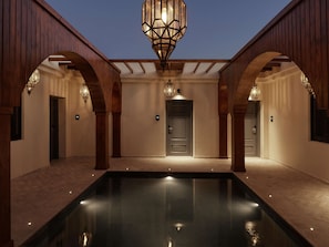 Relax by the serene pool, surrounded by a harmonious blend of wooden beams and neutral tones.
