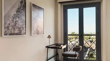 A room with a desk, chair, and two framed pictures on the wall.