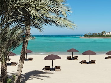 Privatstrand, Sonnenschirme, Strandtücher, Volleyball