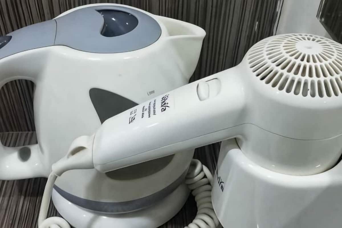 Una tetera eléctrica blanca y un secador de pelo.