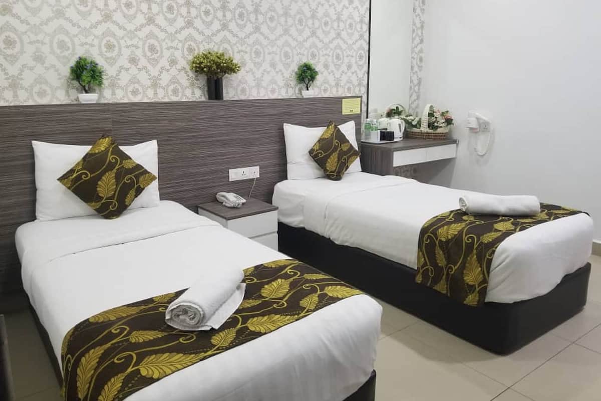 Habitación de hotel con dos camas, una mesita de noche con teléfono, un espejo y televisor montado en la pared.