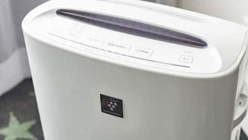 A white portable air purifier with a control panel, placed on a star-patterned carpet.