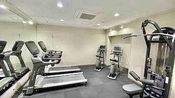 A gym with treadmills, elliptical machines, and a weight machine.