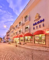 A hotel named Bilgin Hotel with a signboard, red awnings, and a visible pub named Trinity Irish Pub.