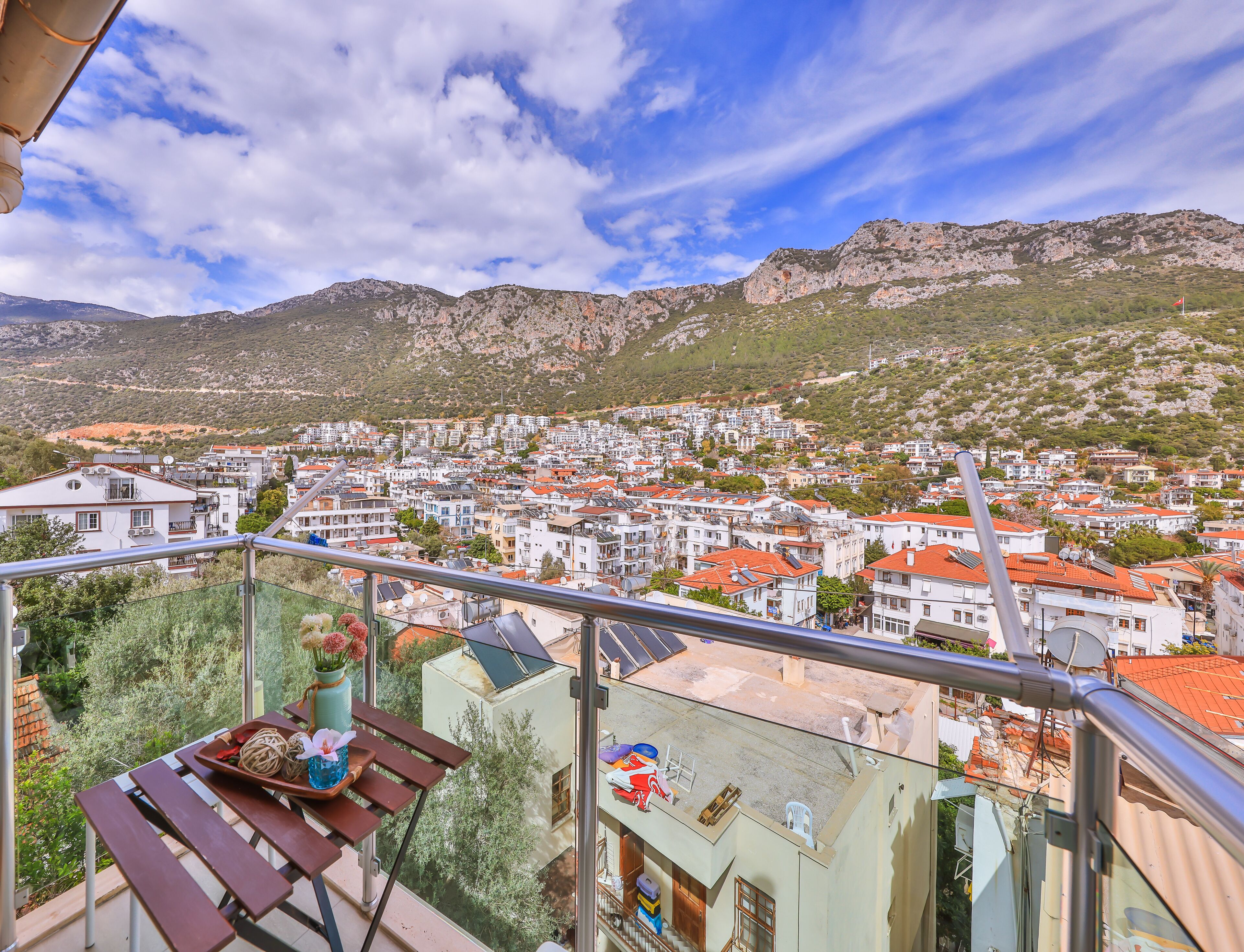 A balcony with a view of a town and mountains.