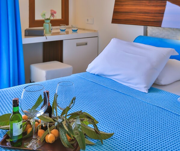 A hotel room with a bed, a bedside table, a small desk, a mirror, and a window with curtains. - Hotel Sonne - Adults Only (Kas)