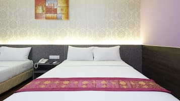 A hotel room with two beds, a nightstand with a phone, and a decorative wall piece.