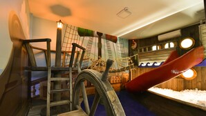A play area with a rope bridge, a slide, and a ship wheel. - Hotel Bertoluci (Gramado)