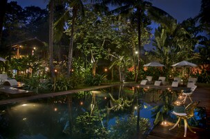 Una piscina al aire libre, sillones reclinables de piscina