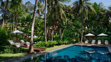 Una piscina al aire libre, sillones reclinables de piscina