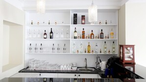 A bar area with shelves of liquor bottles, glasses, and a coffee machine. - Hotel GNG (Tbilisi)