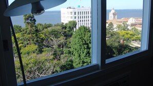 A room with a large window overlooking a cityscape, including a prominent white building and a dome structure. - Hotel Atlantico Rio Grande (Rio Grande)
