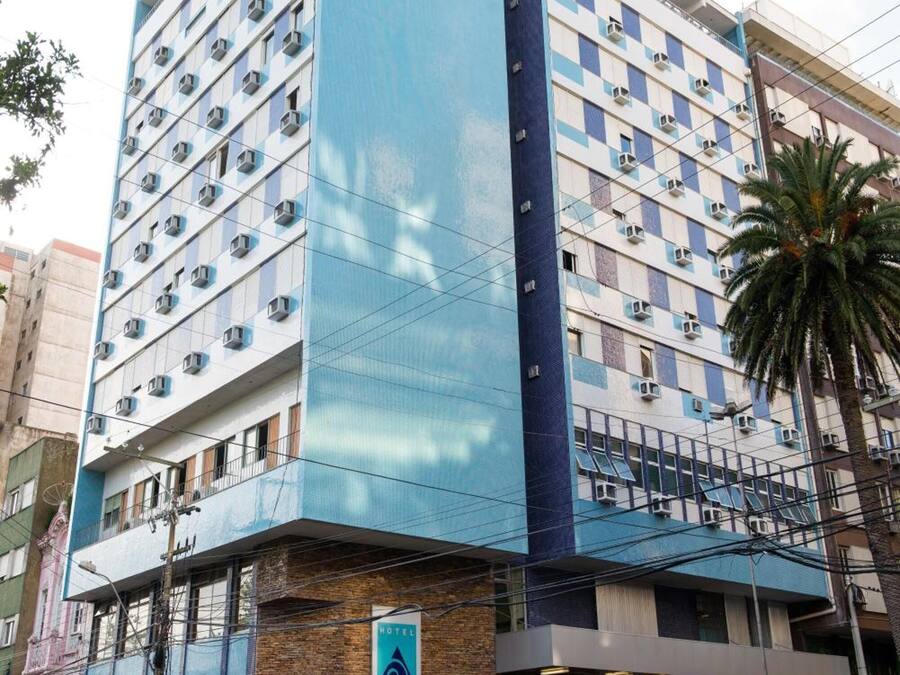 Ein Hotel mit modernem Design, das eine markante blaue Fassade und mehrere Klimaanlagen zeigt.