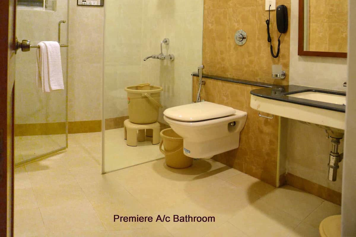 A bathroom with a glass-enclosed shower, a toilet, and a sink.