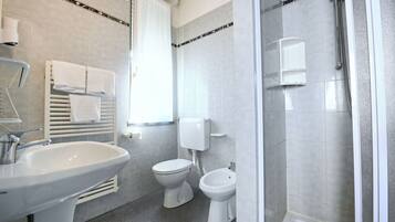 Un baño moderno con lavabo, inodoro, bidé y ducha.
