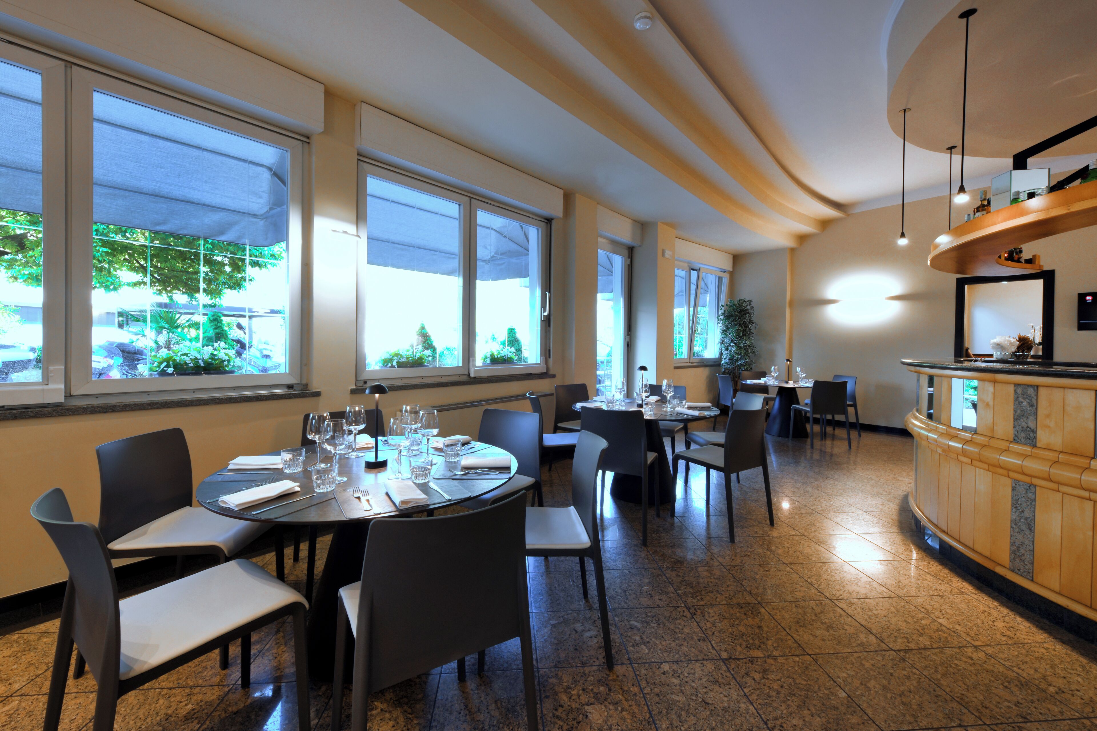 A restaurant with multiple dining tables, chairs, and a counter.