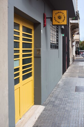A hostel with a yellow door and a sign that reads "Puerto Limón Hostel." - Puerto Limon Hostel (Buenos Aires)