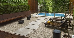 A poolside area with a wooden deck, seating, and a small pool. - Puerto Limon Hostel (Buenos Aires)